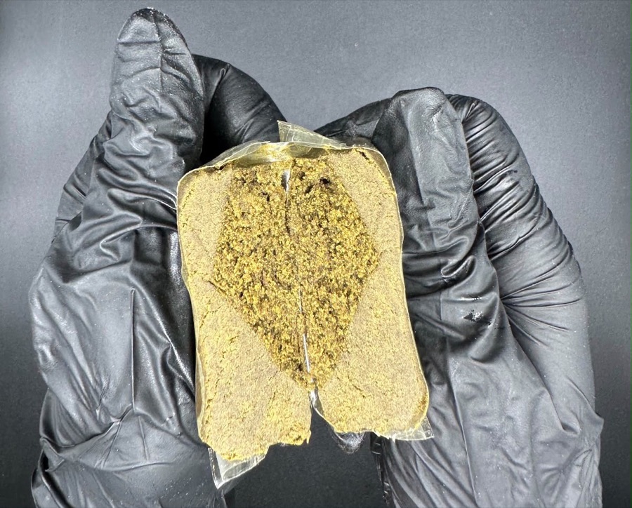 Hash block cut open, held in gloved hands