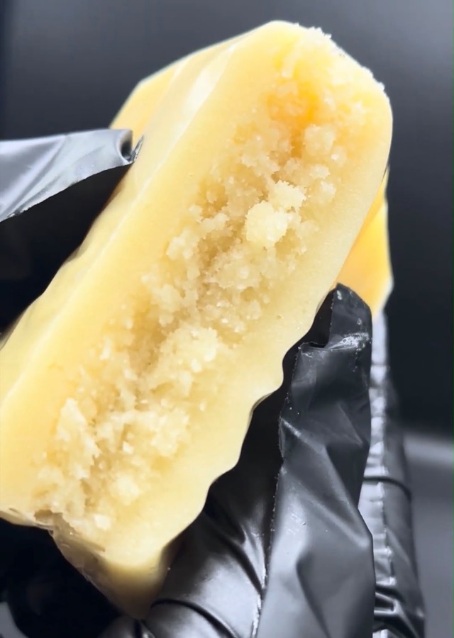 Dark slab held in a gloved hand